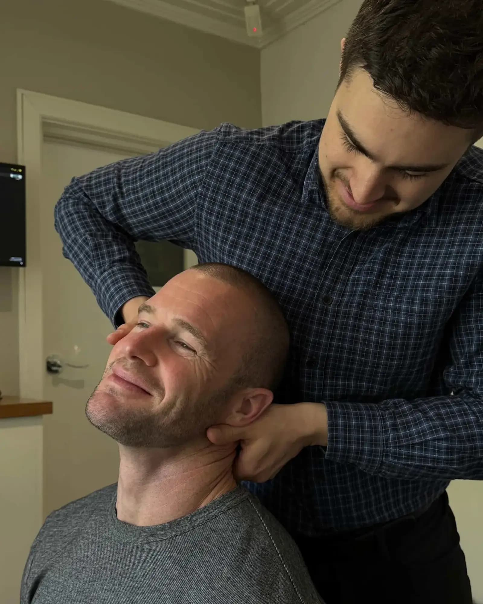 Dr Arthur Kaganovitch adjusting a seated patient's neck at Advanced Chiropractic in Mulgrave