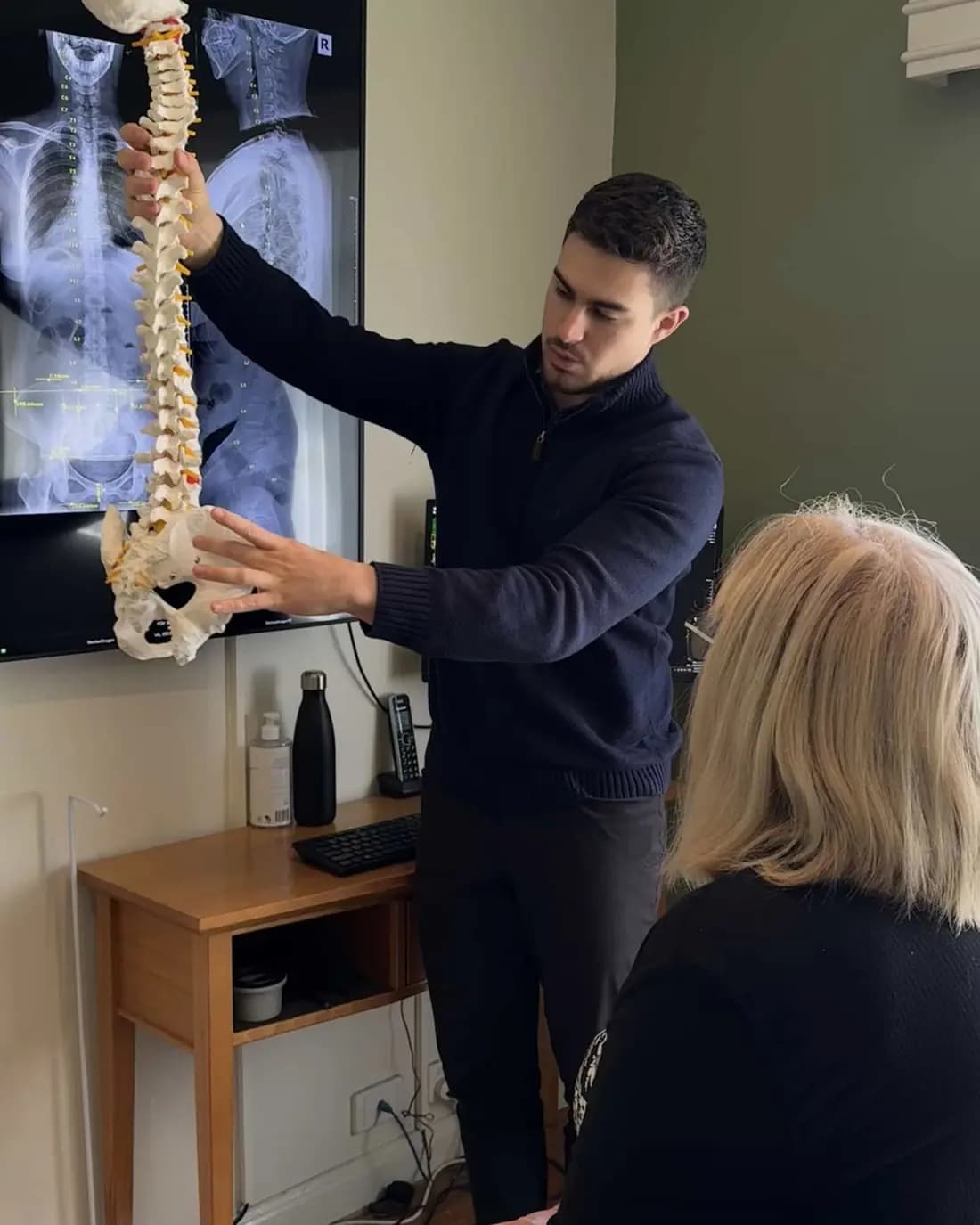 Dr Arthur explaining the spine to a patient with a spine model